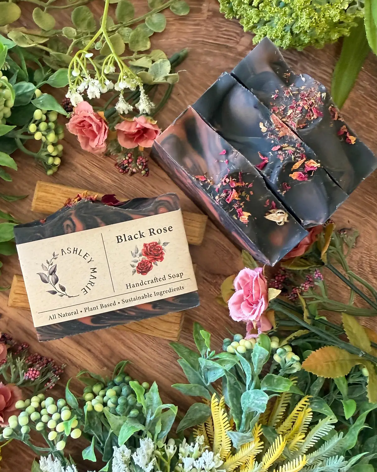 Black Rose Soap photographed on wood with dried flowers