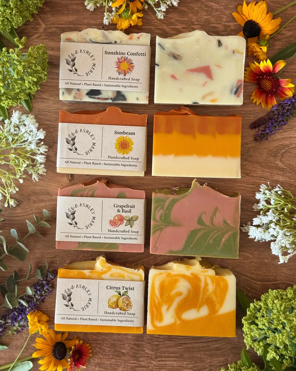 Bars of soap laid out on wood with wildflowers