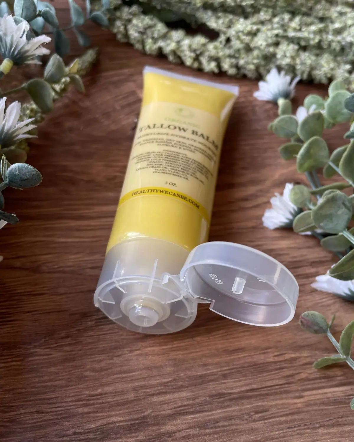 Tallow Balm photographed on wood with dried flowers